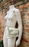 Small leather bag in cream beige. Cross body or shoulder bag in GENUINE leather. Beige leather bag with adjustable strap, zipper and flap.