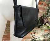 Small leather bag in black. Cross body or shoulder bag in GENUINE leather. Black leather bag with adjustable strap, zipper and flap.